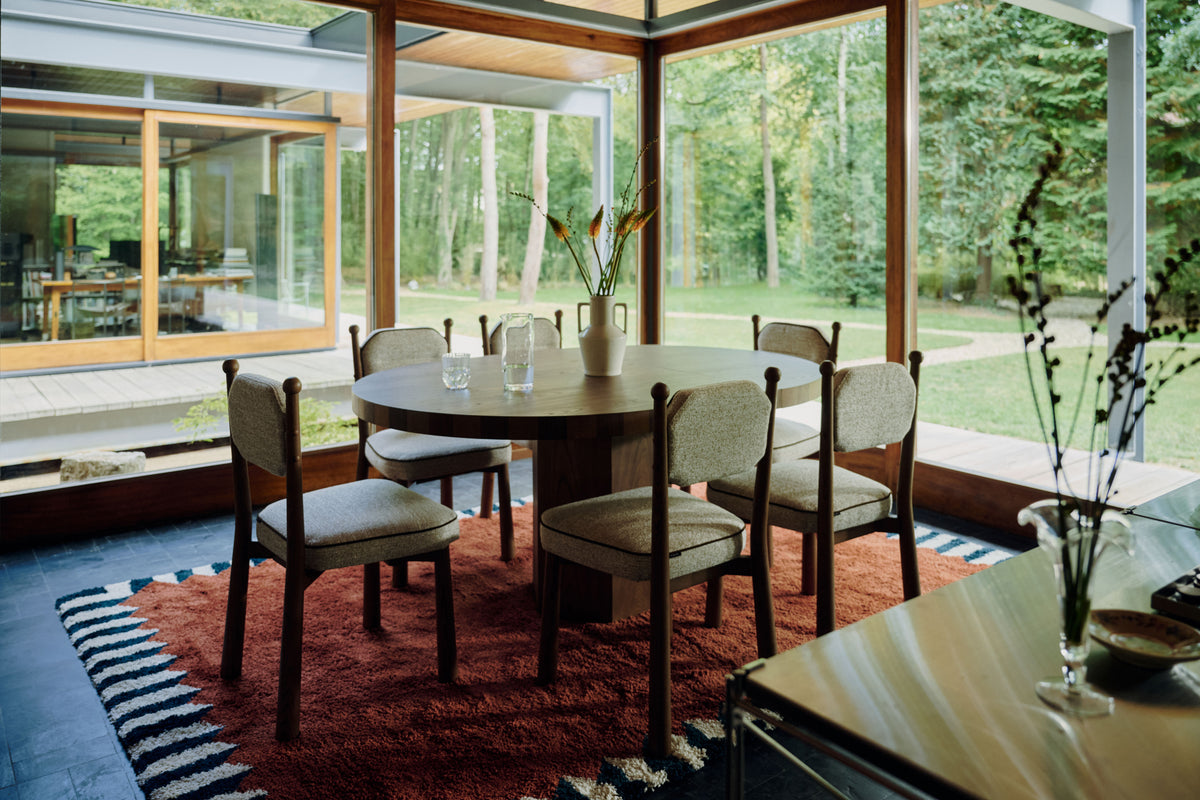 six chaises Anna en tissu chiné beige autour de la table ronde Modanata en chêne