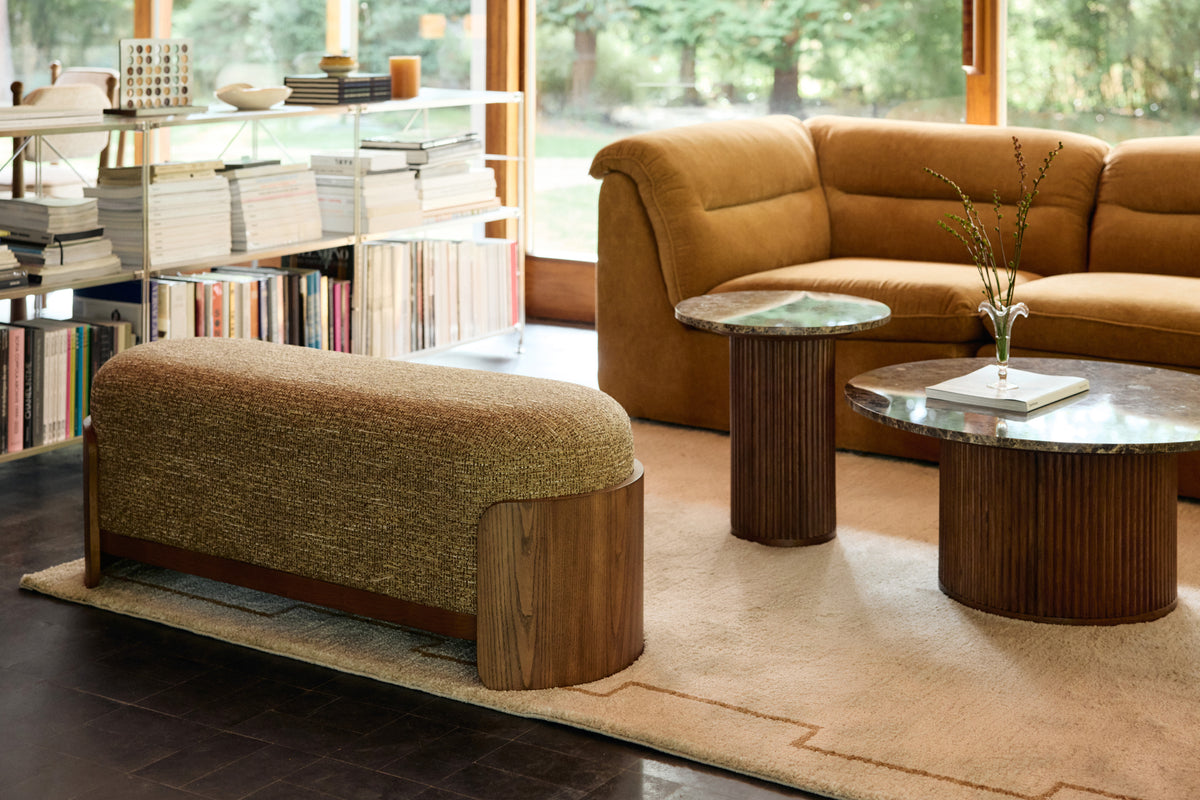 banc Ellipse en tissu chiné ocre et tables basses Oviedo dans un salon vitré