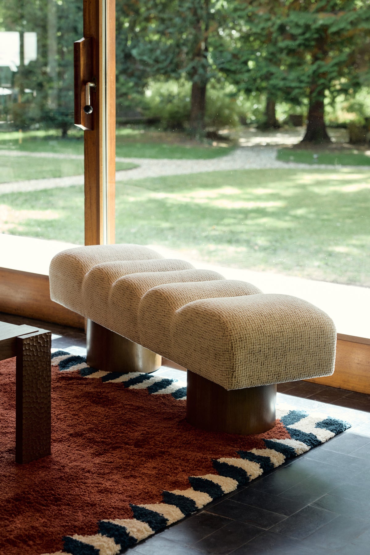 banc Nova en tweed beige moucheté et socles cylindriques - vue de trois-quarts