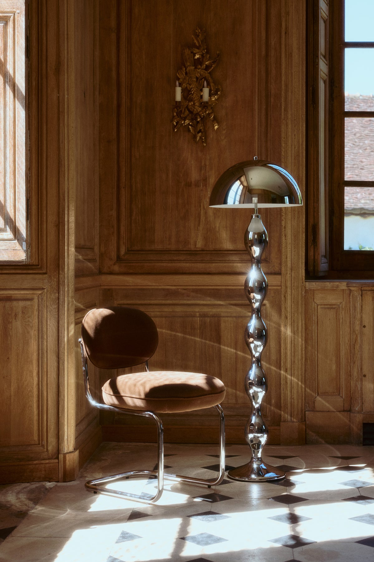 lampadaire Powers - acier chromé poli forme organique - mise en situation château boiseries et carrelage damier avec chaise velours