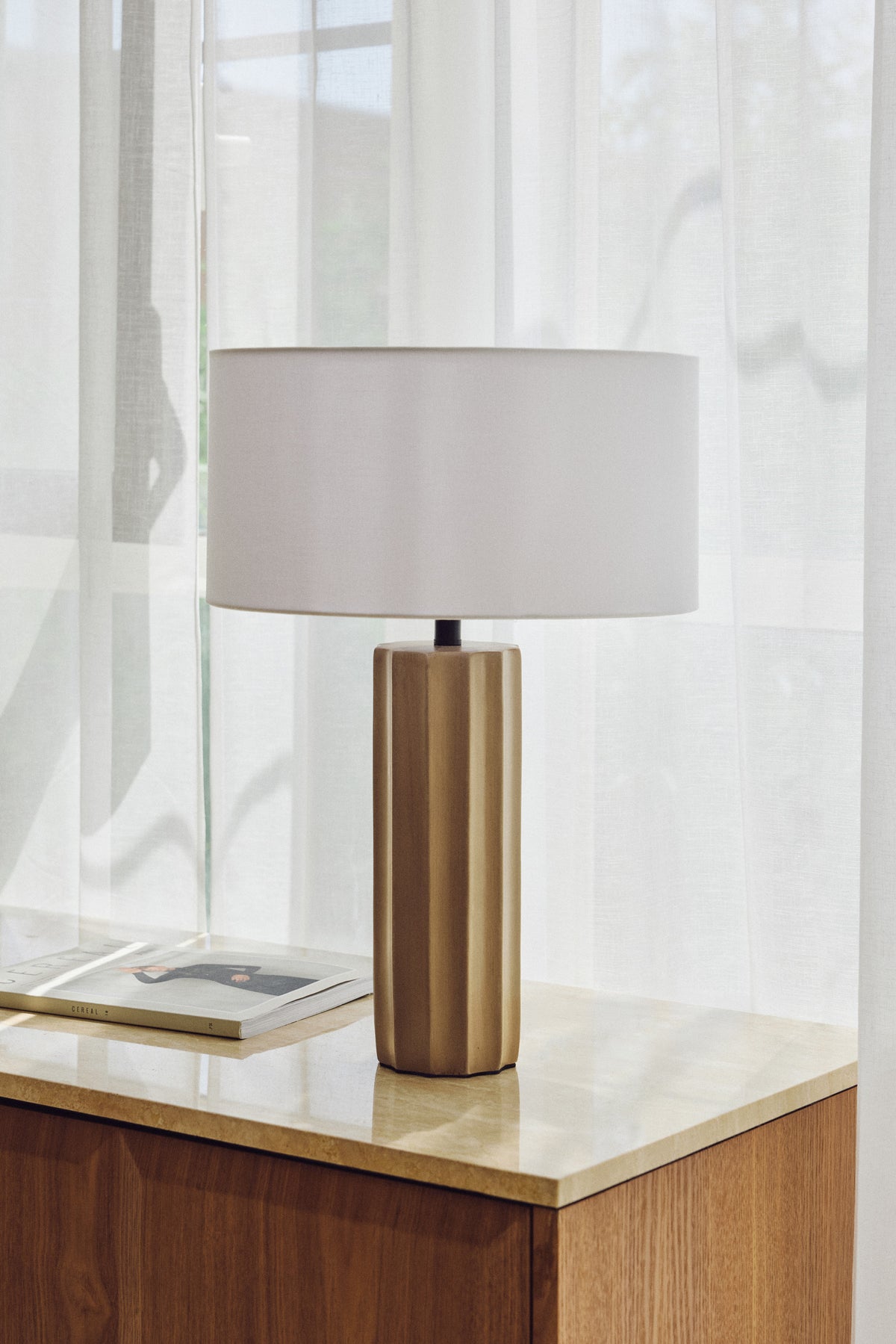 lampe Zahara - beton cannelé et abat-jour lin blanc - vue portrait sur buffet travertin