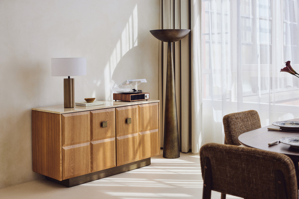 buffet Stamford bois blond et travertin, lampe Zahara beton et lampadaire Olympe bronze
