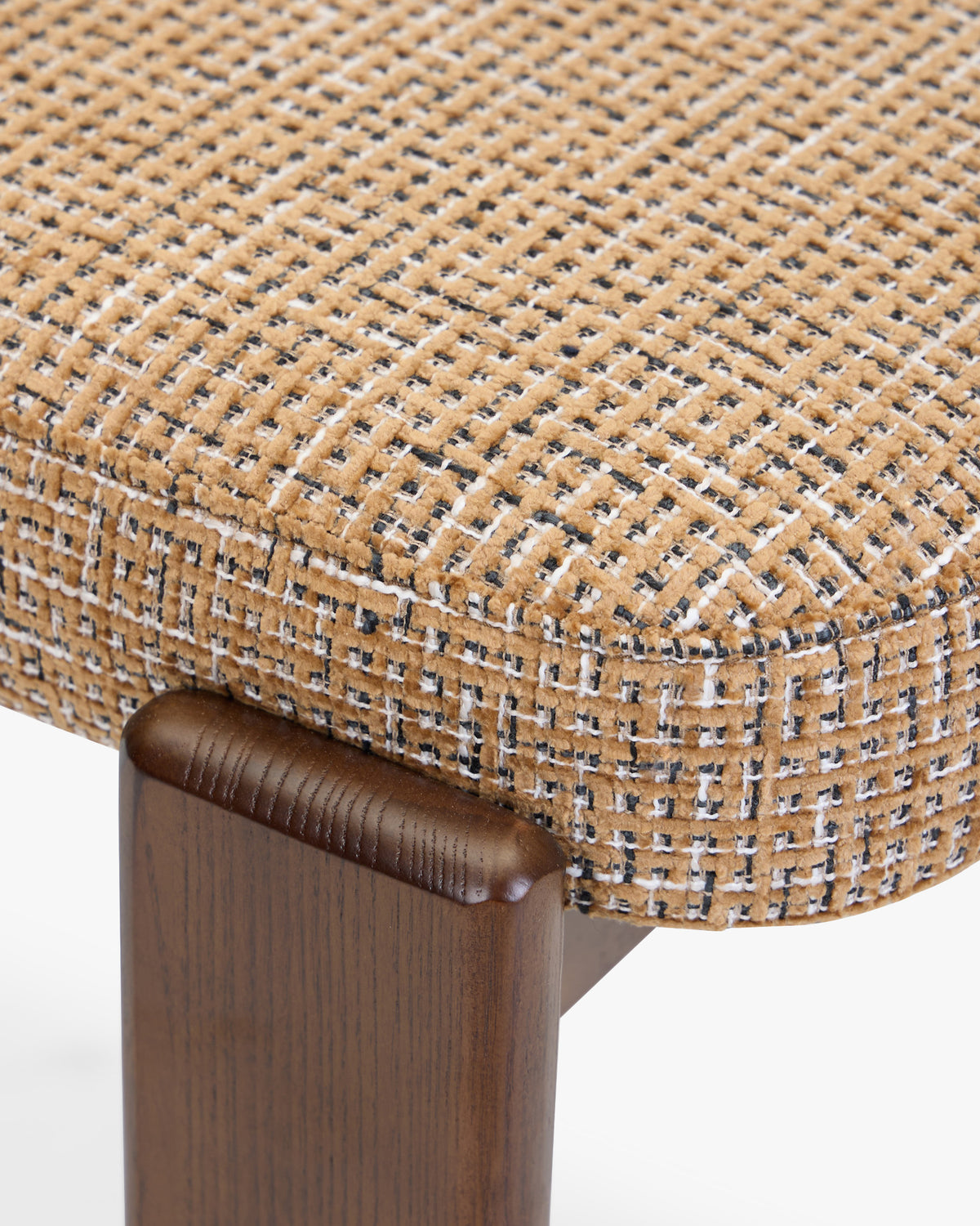 gros plan sur l'assise en tweed marron caramel et le pied avant en frêne d'une chaise MELIANA