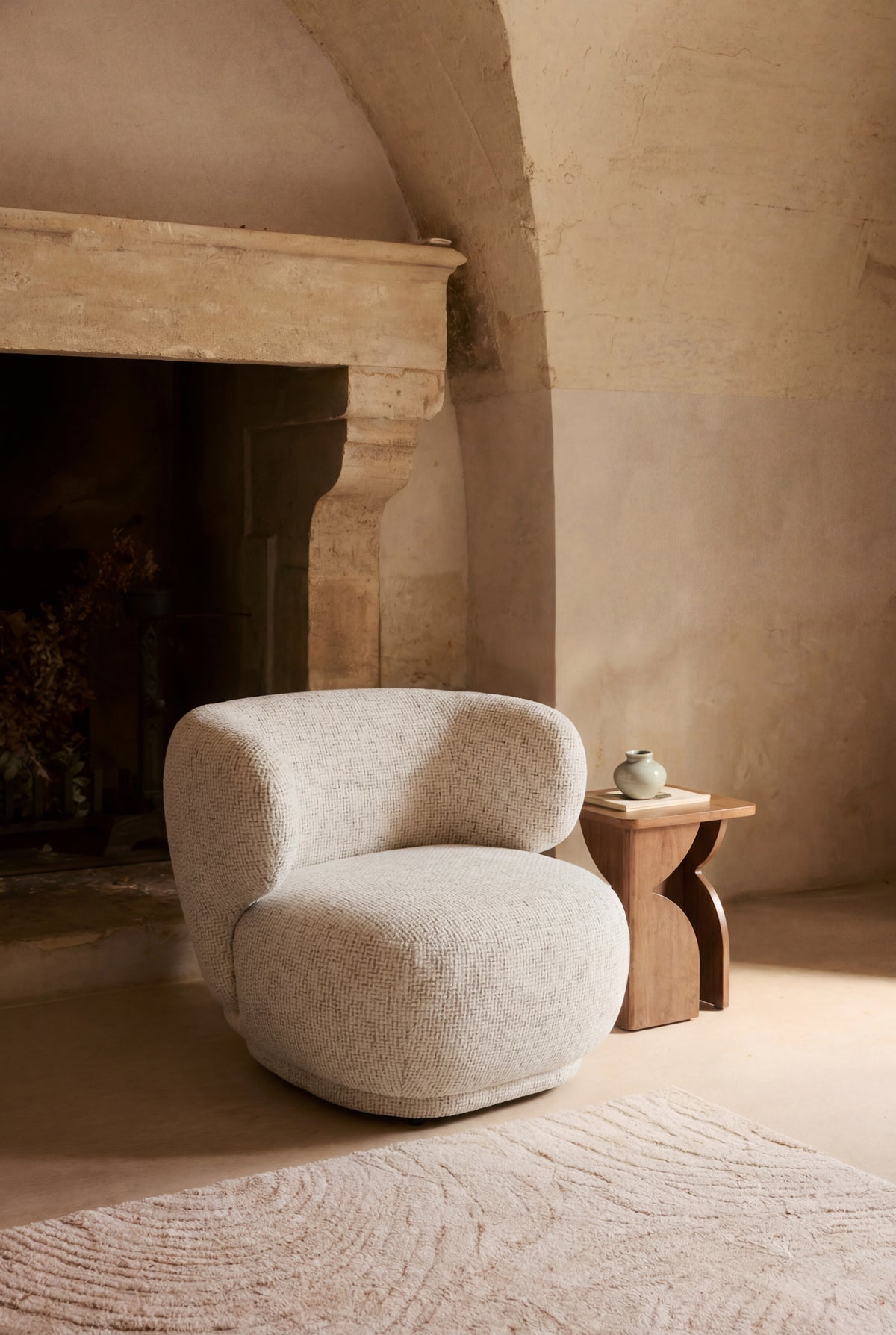 fauteuil Giulia - tweed beige moucheté - vue portrait ambiance cheminée en pierre
